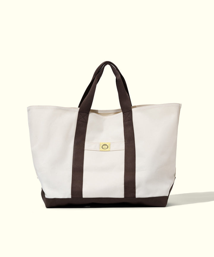 Beach Tote in white with brown straps, perfect for carrying everything you need for a day out. Sun Bum.