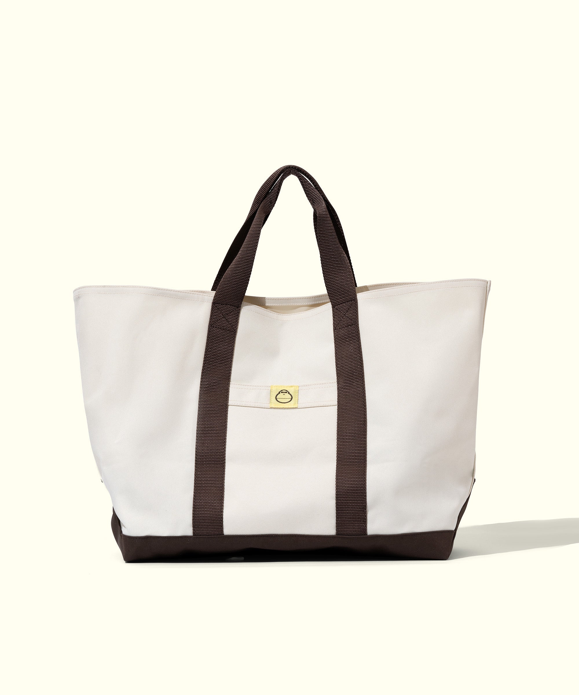 Beach Tote in white with brown straps, perfect for carrying everything you need for a day out. Sun Bum.