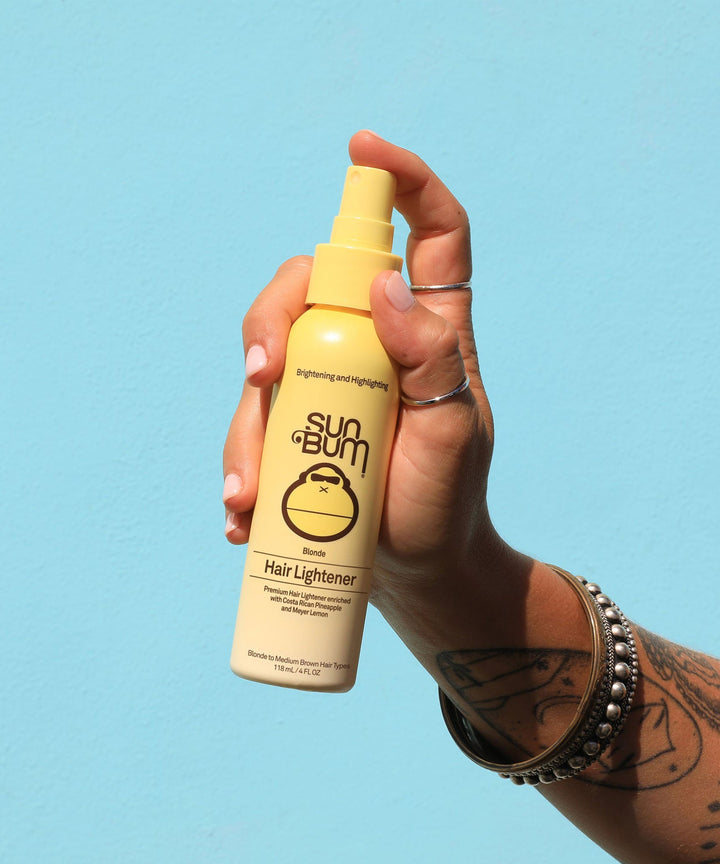 Blonde Hair Lightener spray held by a hand, featuring a yellow bottle labeled 